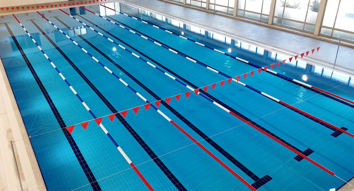 FINA standartlarına uygun çizgilendirme ve kulvar ayırıcılarına sahip kapalı olimpik yüzme havuzu.